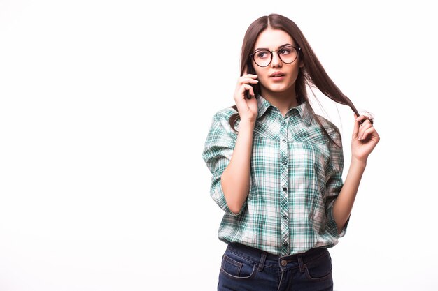 Jovem mulher elegante falando no celular contra um branco