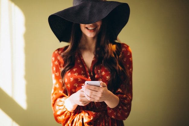 Jovem mulher em um lindo vestido usando telefone e compras on-line