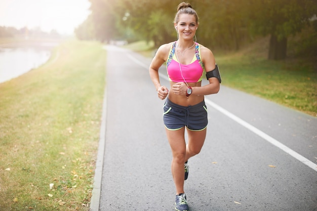 Jovem mulher exercitando ao ar livre. A corrida matinal me dá energia para o dia todo