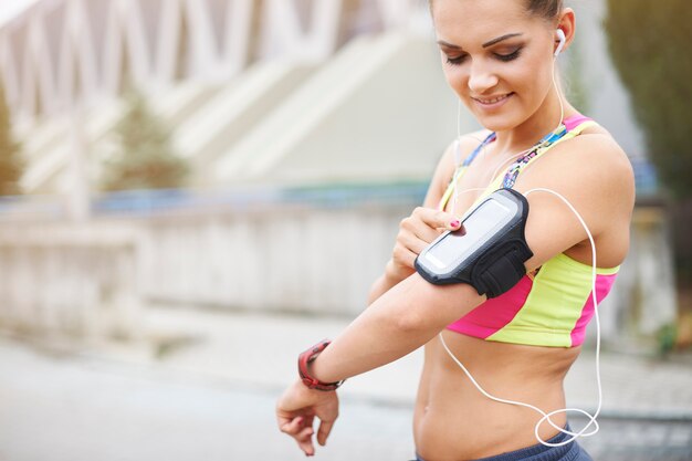 Jovem mulher exercitando ao ar livre. Este gadget é muito útil para correr