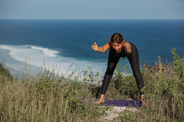 Foto grátis jovem mulher fazendo ioga ao ar livre com incrível vista traseira. bali. indonésia.