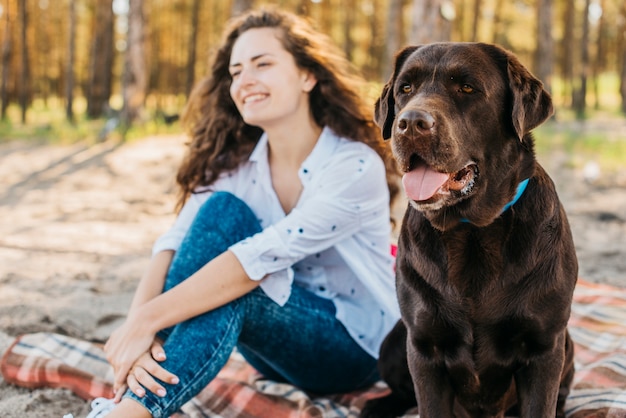 Jovem mulher fazendo um piquenique com seu cachorro