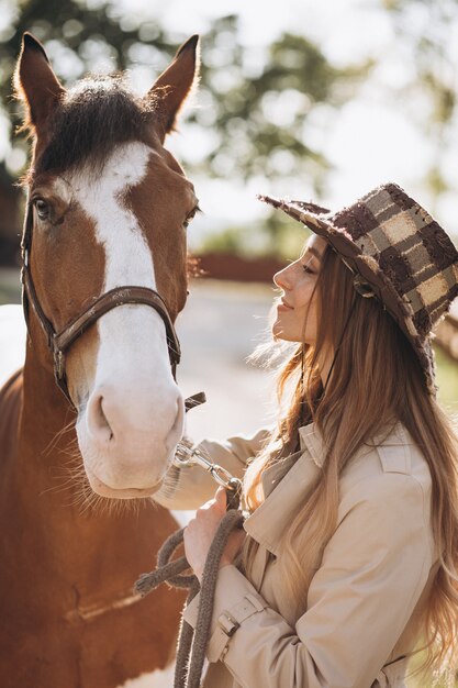 Jovem mulher feliz com cavalo no rancho