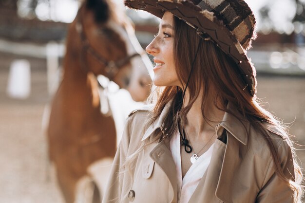 Foto grátis jovem mulher feliz com cavalo no rancho