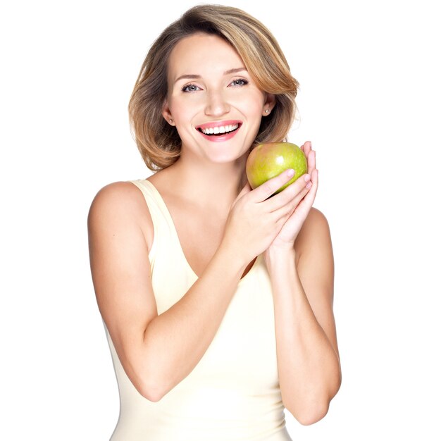 Jovem mulher feliz e sorridente com maçã verde isolada no branco.