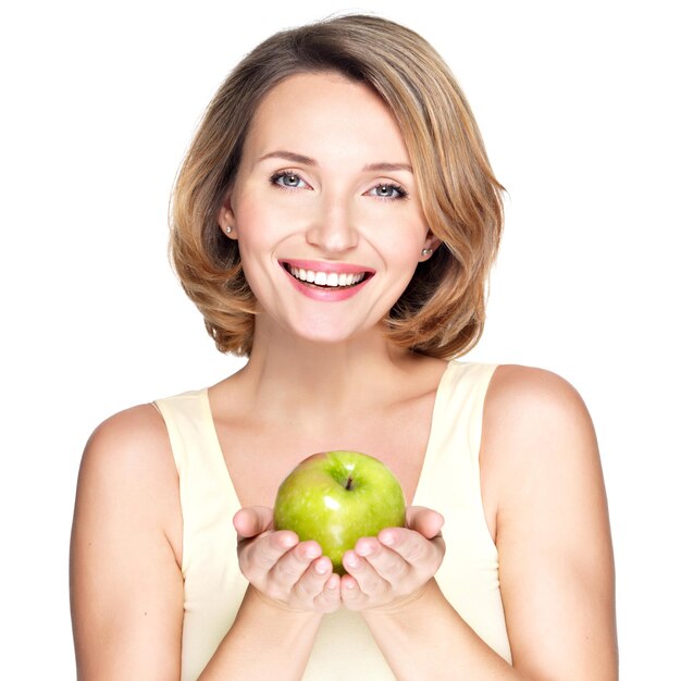 Jovem mulher feliz e sorridente com maçã verde - isolada no branco.