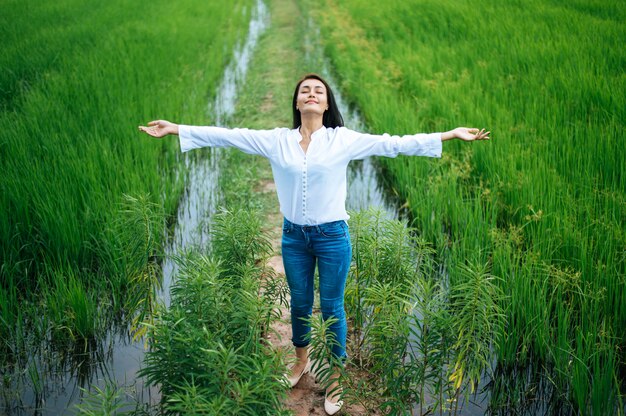 Jovem mulher feliz em um campo verde em dia de sol