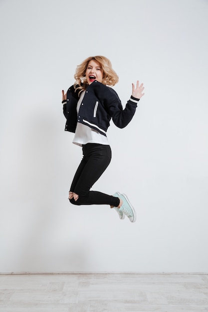 Foto grátis jovem mulher feliz pulando e comemorando o sucesso
