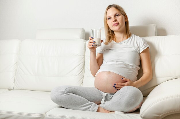 Jovem mulher grávida bebendo leite