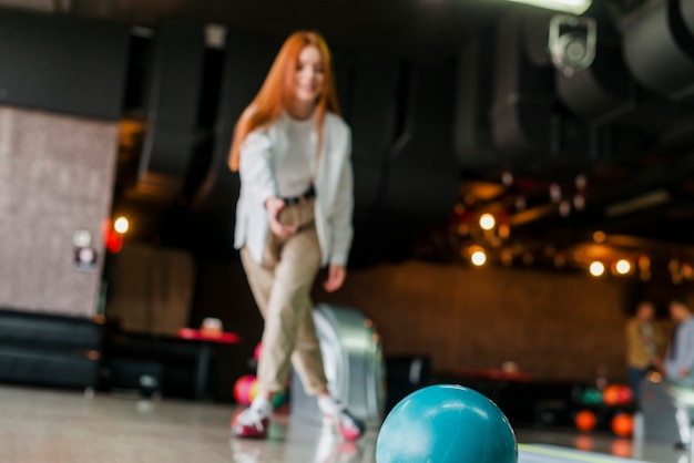 Foto grátis jovem mulher jogando a bola de boliche