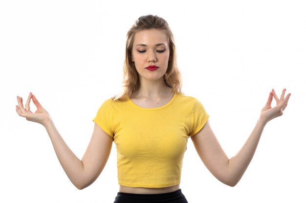 Jovem mulher loira com camiseta amarela meditando