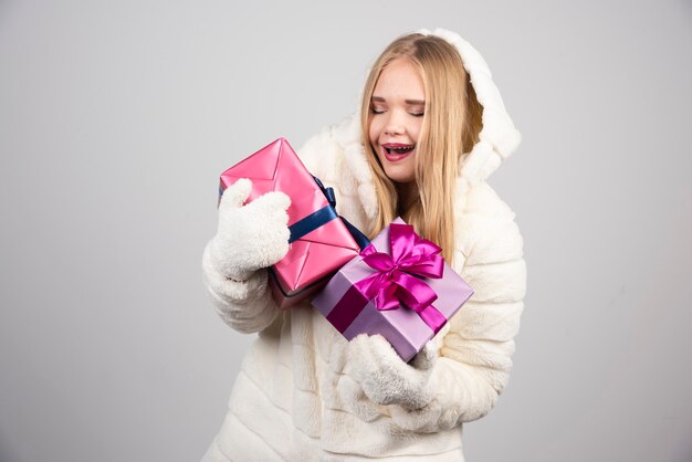 Jovem mulher loira olhando para os presentes de Natal.