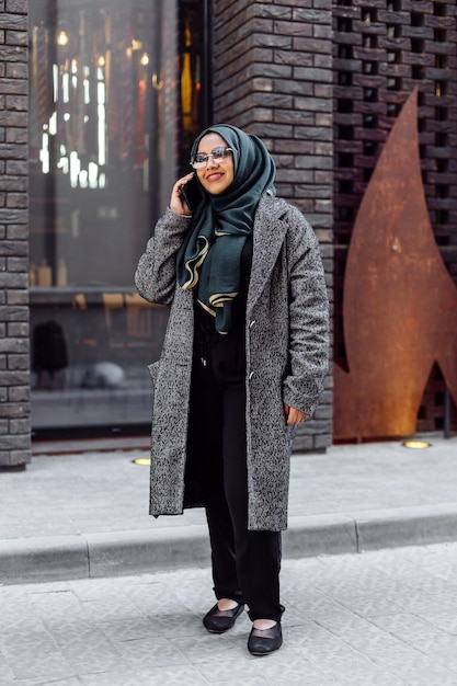 Foto grátis jovem mulher muçulmana falando ao telefone