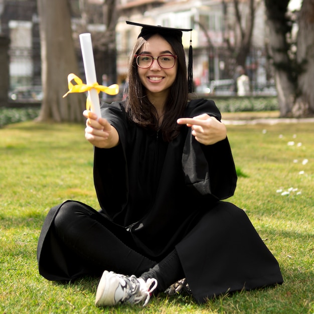 Foto grátis jovem mulher na cerimônia de formatura fora