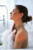 Foto grátis jovem mulher nua tomando um relaxante banho de espuma