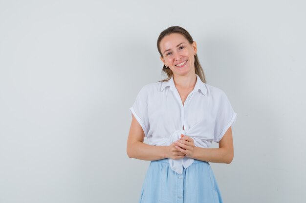 Jovem mulher olhando para a frente com blusa e saia e parecendo otimista