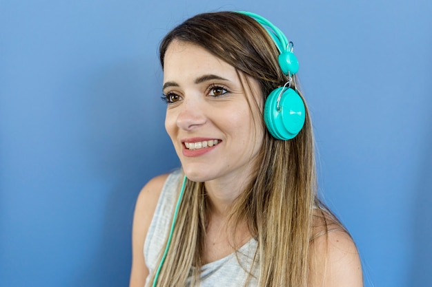 Foto grátis jovem mulher ouvindo música com fones de ouvido