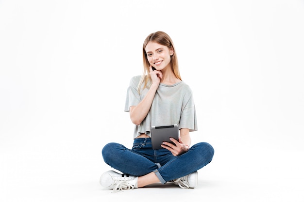 Foto grátis jovem mulher posando com tablet isolado