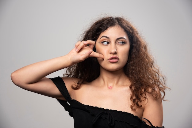 Foto grátis jovem mulher posando de blusa preta com cabelo encaracolado. foto de alta qualidade