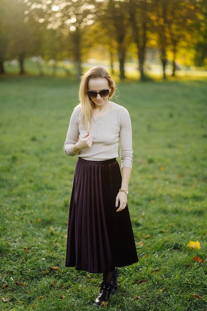 Jovem Mulher Posando Sobre Folhas Amarelas No Parque Do Outono. Ao ar livre