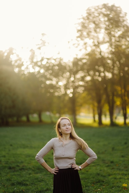 Foto grátis jovem mulher posando sobre folhas amarelas no parque do outono. ao ar livre