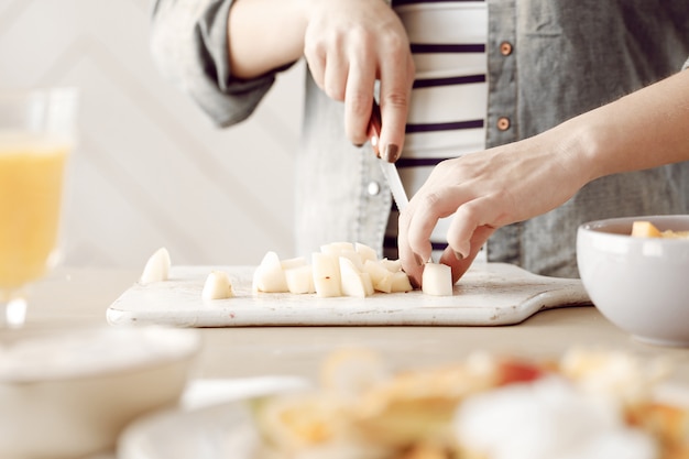 Jovem mulher prepara café da manhã na cozinha