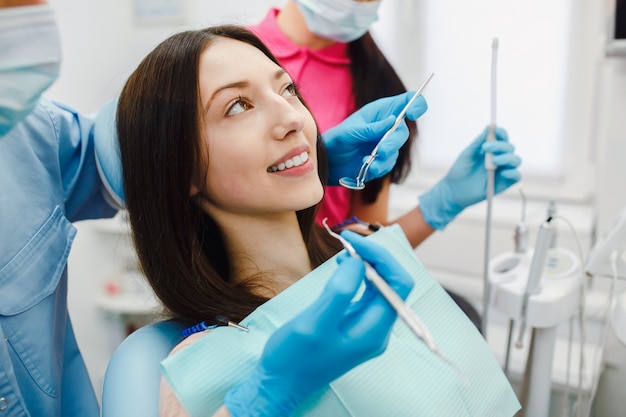 Jovem mulher que tem um tratamento dentário na clínica