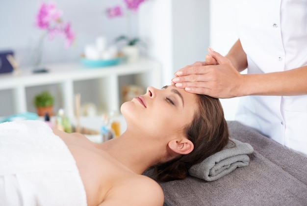 Jovem mulher recebendo massagem facial profissional