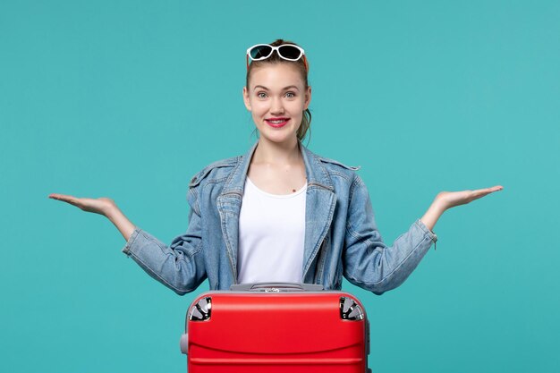 Jovem mulher se preparando para a viagem e sorrindo no espaço azul