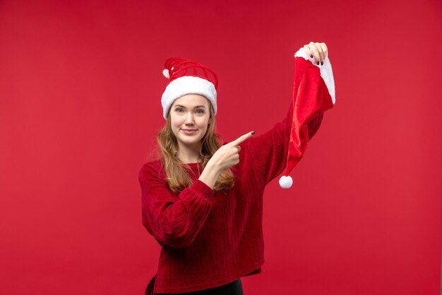 Jovem mulher segurando a tampa vermelha sorrindo, vista frontal, natal, feriado, natal