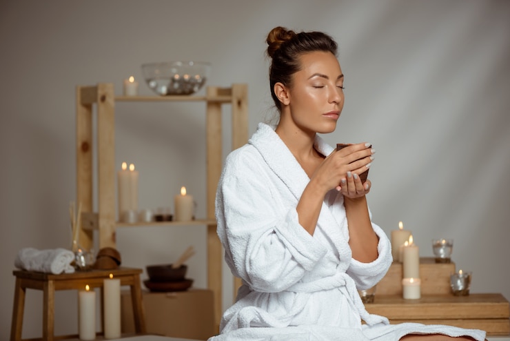Foto grátis jovem mulher segurando a xícara de chá relaxante no salão spa.
