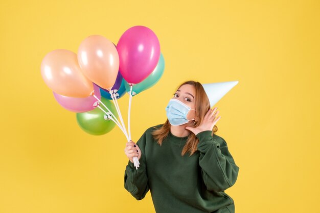 Jovem mulher segurando balões coloridos