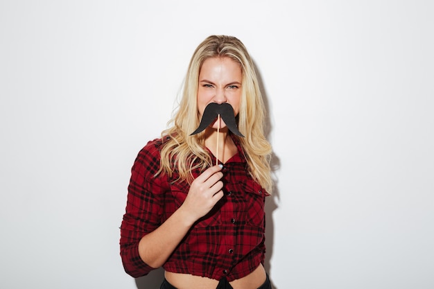 Foto grátis jovem mulher segurando bigode falso