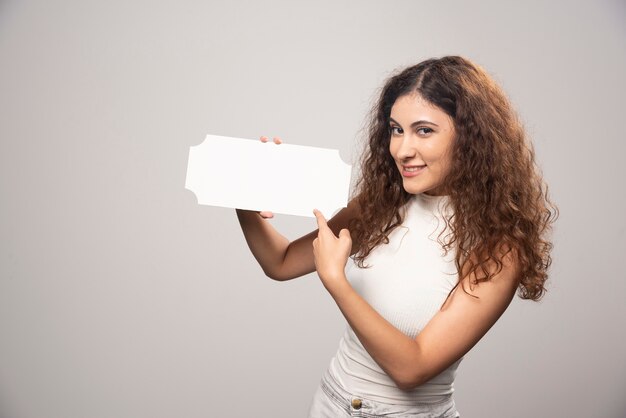 Jovem mulher segurando o cartaz de discurso branco em branco vazio. Foto de alta qualidade