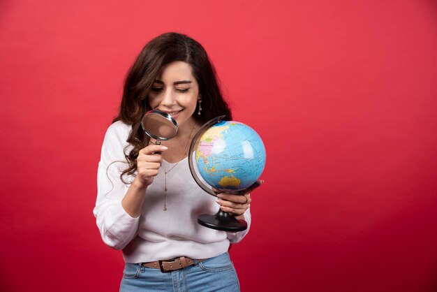 Jovem mulher segurando o globo e a lupa. Foto de alta qualidade