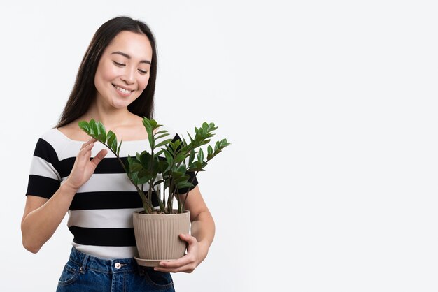 Jovem mulher segurando o vaso de flores