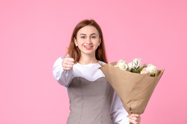 Jovem mulher segurando um buquê de lindas rosas na frente