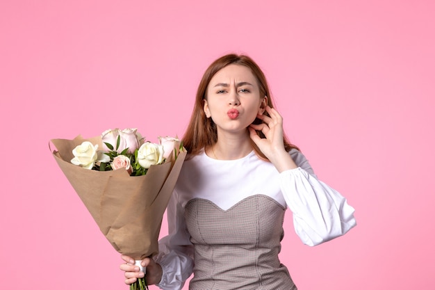 Jovem mulher segurando um buquê de lindas rosas na frente