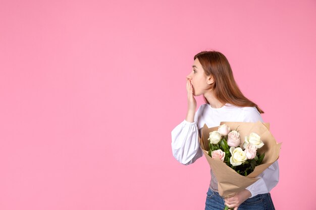 Jovem mulher segurando um buquê de lindas rosas na frente