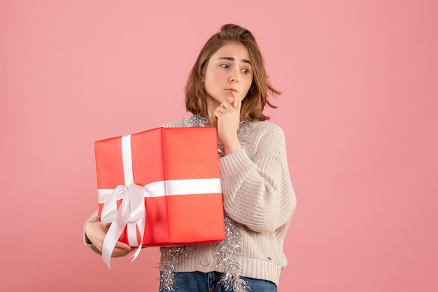 Jovem mulher segurando um presente de natal de frente