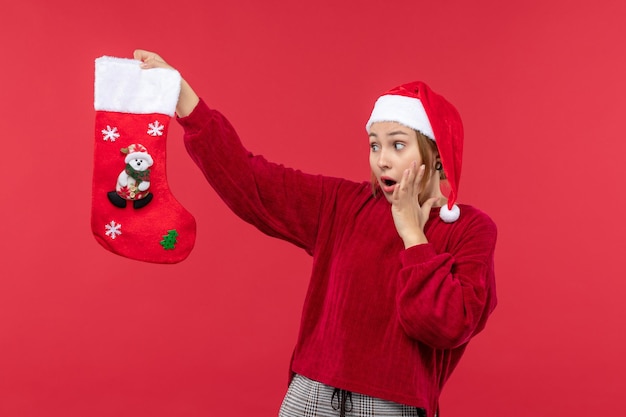 Jovem mulher segurando uma meia de natal, vermelho, vista de frente, feriados de natal