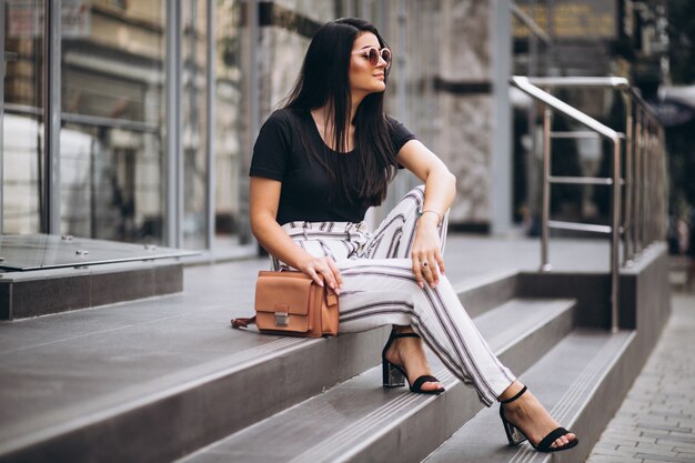 Jovem mulher sentada nas escadas do edifício