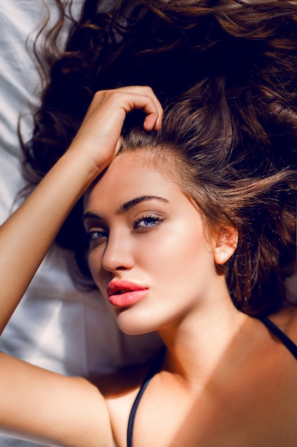 Jovem mulher sexy em lingerie preta posando na cama