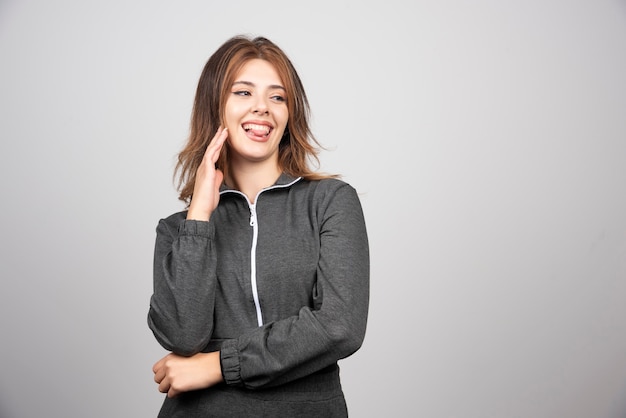 Jovem mulher sorridente em pé e posando.