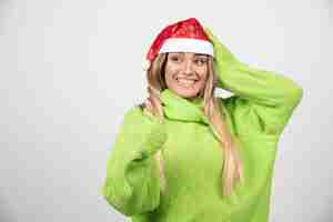 Foto grátis jovem mulher sorridente, posando com chapéu vermelho de papai noel.