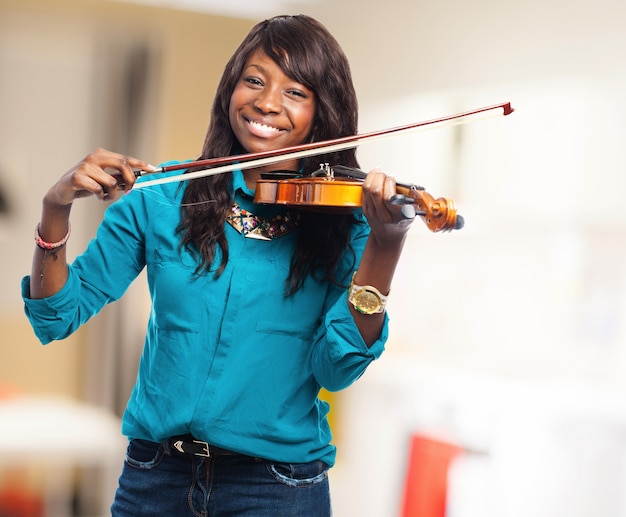 Jovem, mulher, sorrindo, enquanto a tocar violino