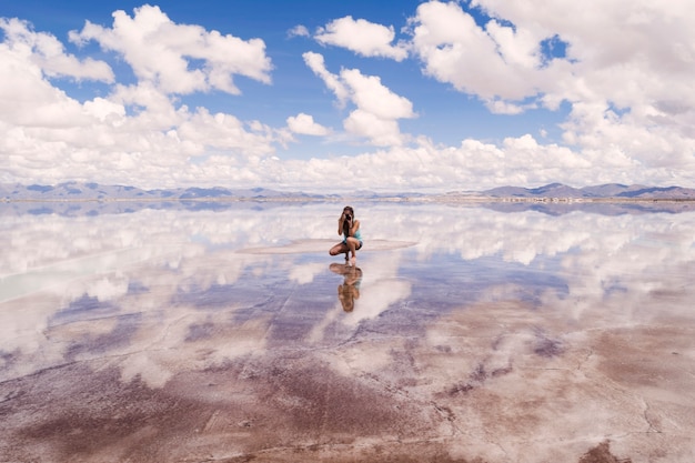 Jovem mulher tirando foto de reflexo de água bonita