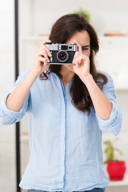 Jovem mulher tirando uma foto com uma câmera