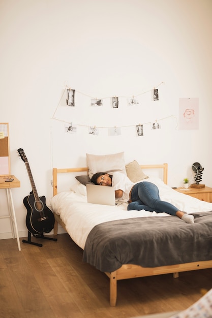 Foto grátis jovem mulher tiro no laptop no quarto