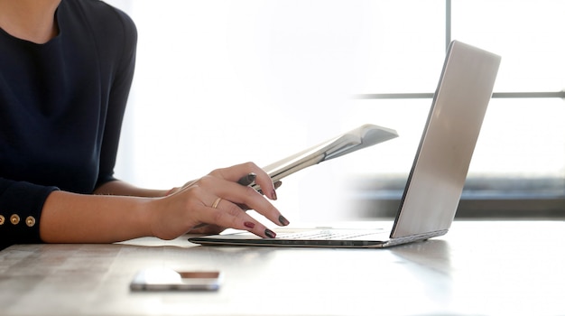 Foto grátis jovem mulher trabalhando com laptop e agenda